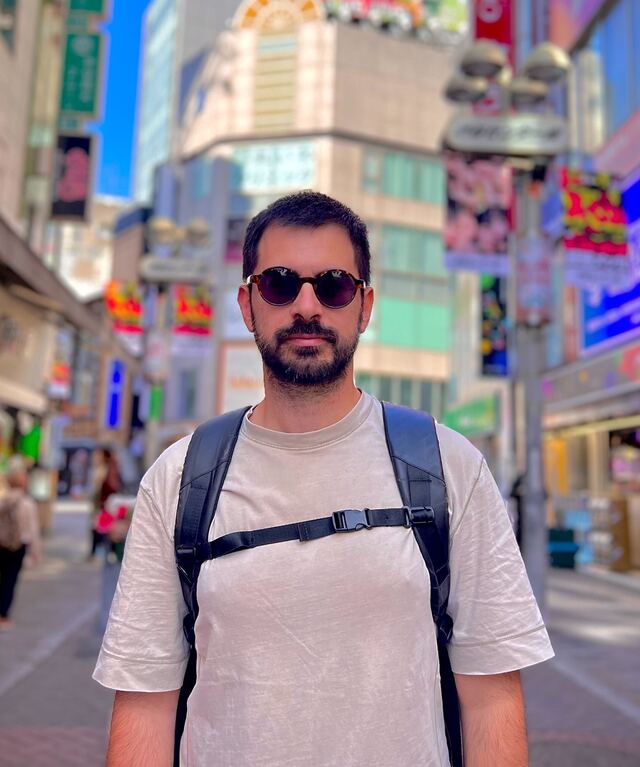 Luís Zamith Ferreira, in sunglasses and a backpack, on a busy shopping street.